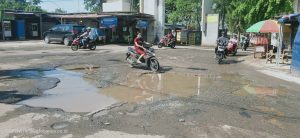 Kondisi Jalan Depan Gerbang Perum De Griya Rusak Dan Berlubang