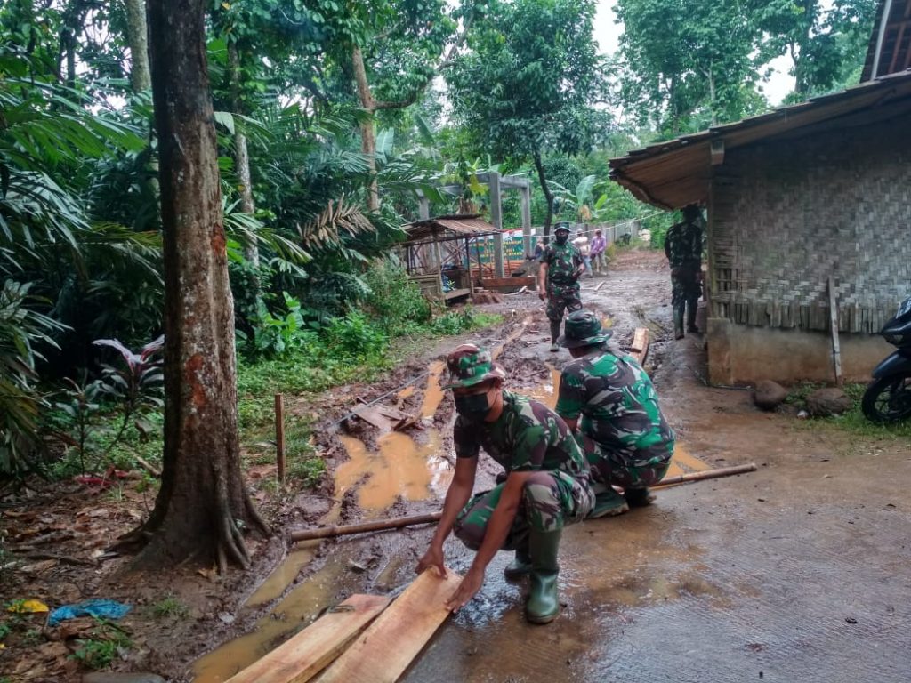 SATGAS TMMD BERSAMA WARGA LAKUKAN PEMASANGAN PAPAN BEKISTlNG DALAM PENGECORAN JALAN