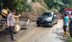 TANGGAP BENCANA, PERSONIL POLSEK BATANG NATAL BERSAMA MASYARAKAT BERSIHKAN MATERIAL LONGSOR DI DESA TARLOLA